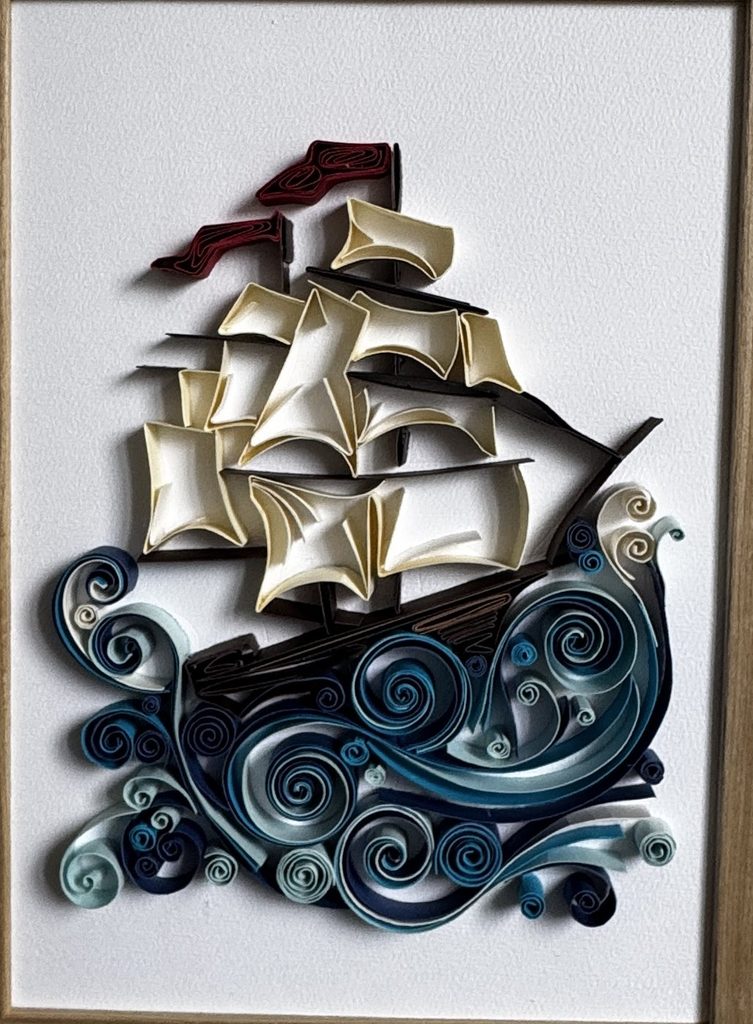 Voilier en papier roulé sur des vagues bleues