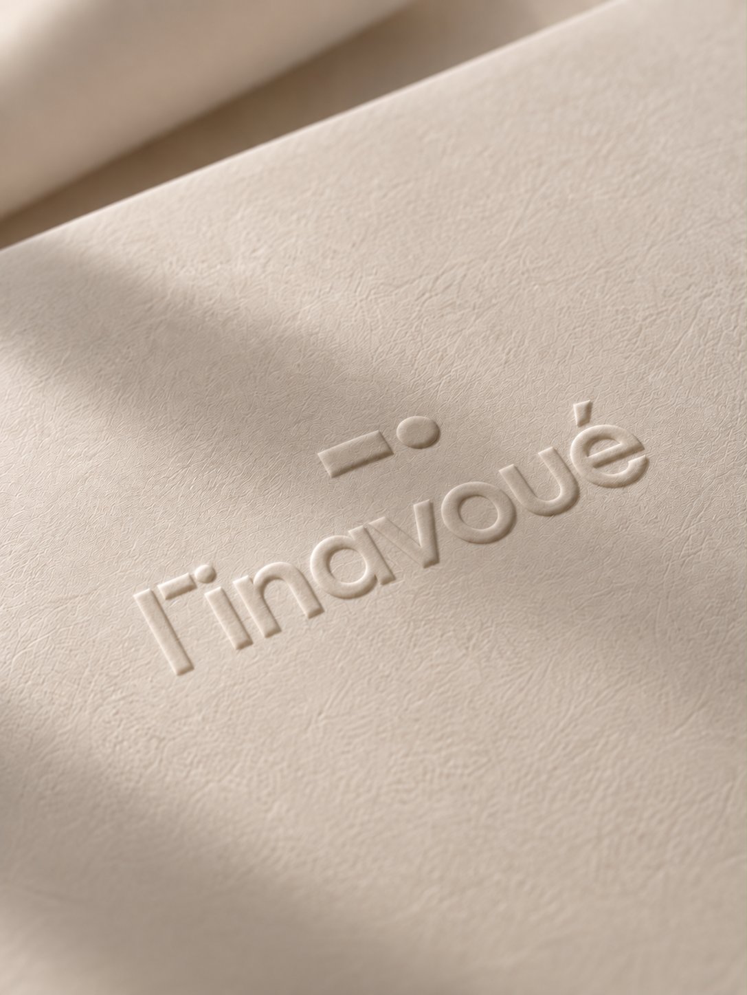 Le logo l'inavoué gaufré sur un papier crème